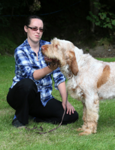 Woman brushing her dog in the woods