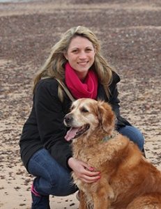 Woman petting her dog on the beach