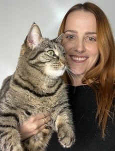 Woman holding in her arms a big mackerel tabby cat